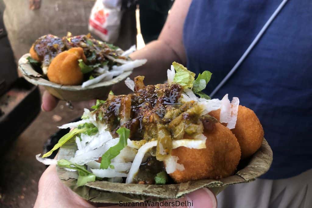 two plates of ram ladoo being held