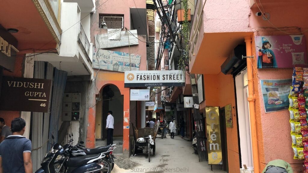 Fashion Street in Shahpur Jat with motorcycle and orange painted buildings