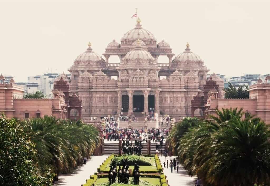long view of Akshardham Temple with palm trees and walkway down the middle