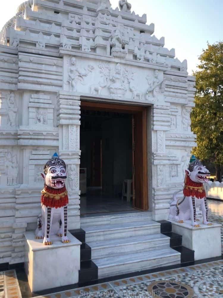 Exterior of the main shrine at Shri Neelanchal Seva Sangh with two stone lions guarding the entrance / 21 Famous and Unique Temples in Delhi
