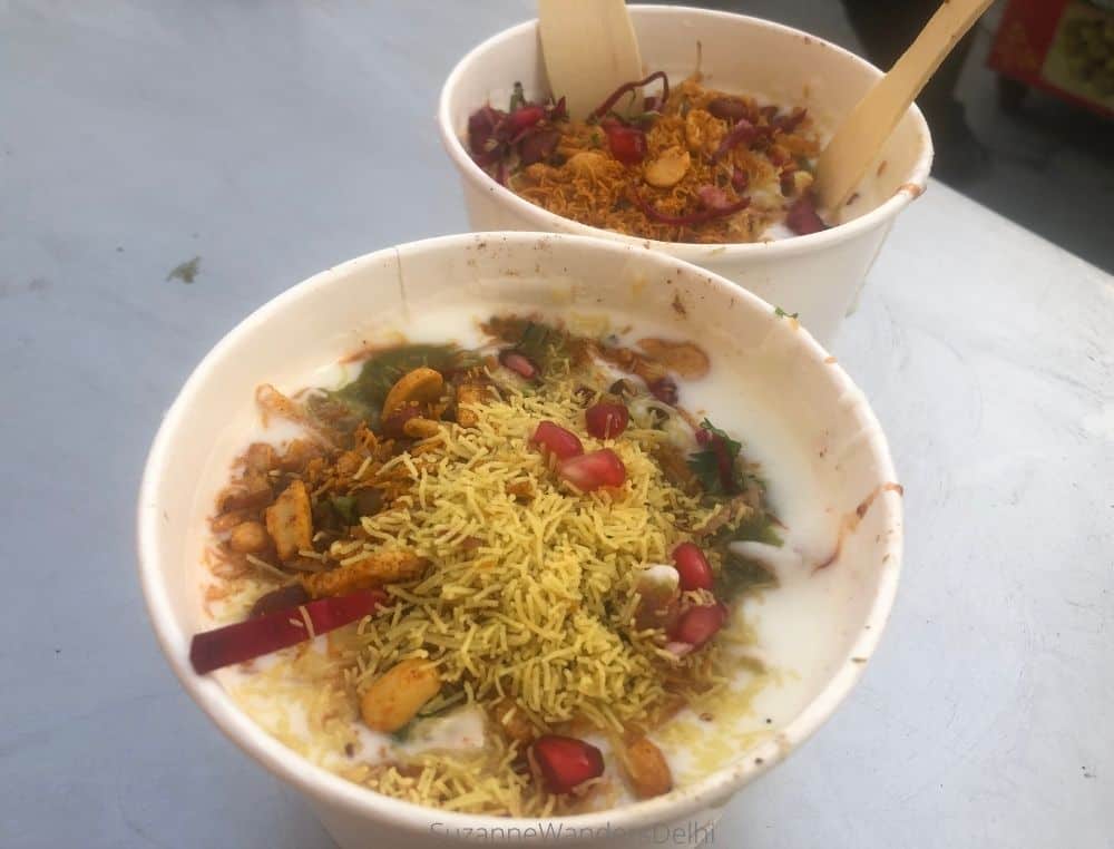 two paper bowls of papri chaat on a white table top