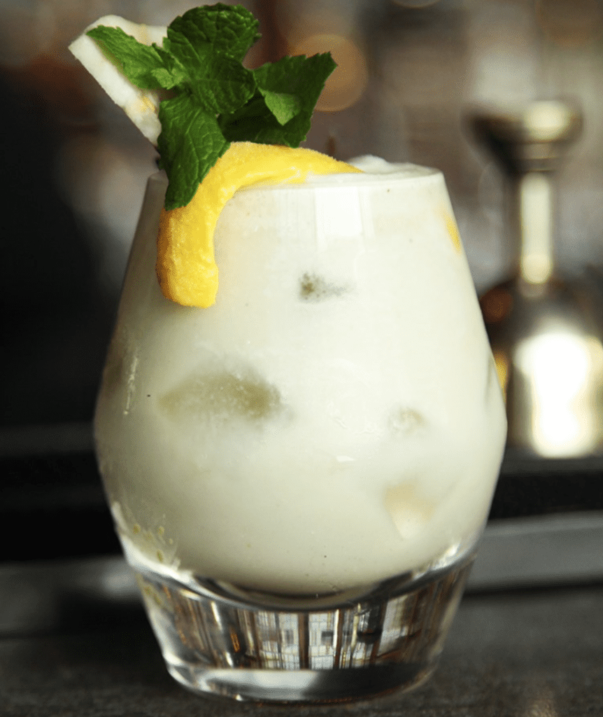 Creamy cocktail with lemon and mint garnish / The Best Party Places in Delhi