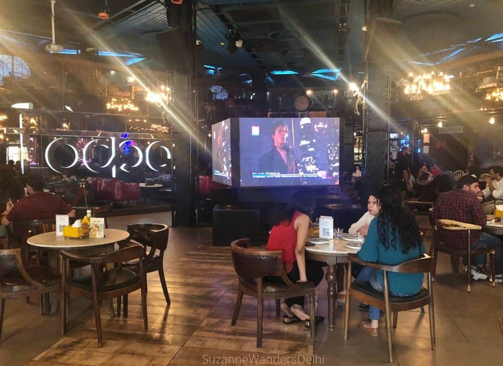 View of the giant TV screens and tables with diners / The Best Party Places in Delhi