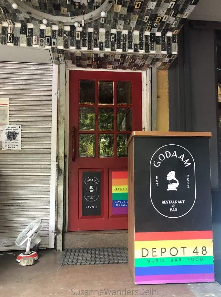 Front door of Depot 48 with signage in rainbow colours