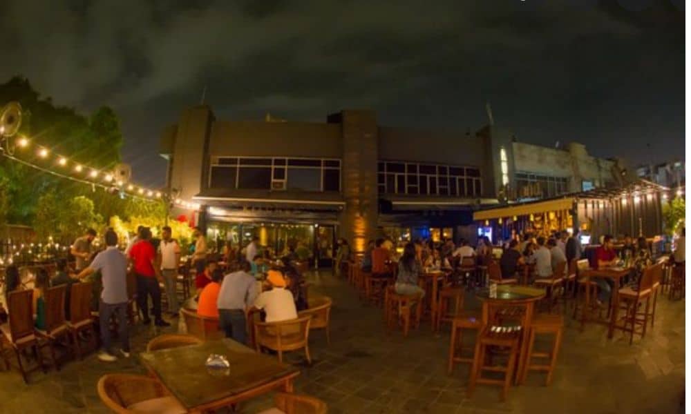 Outdoor rooftop terrace crowded with people at night / The Best Party Places in Delhi
