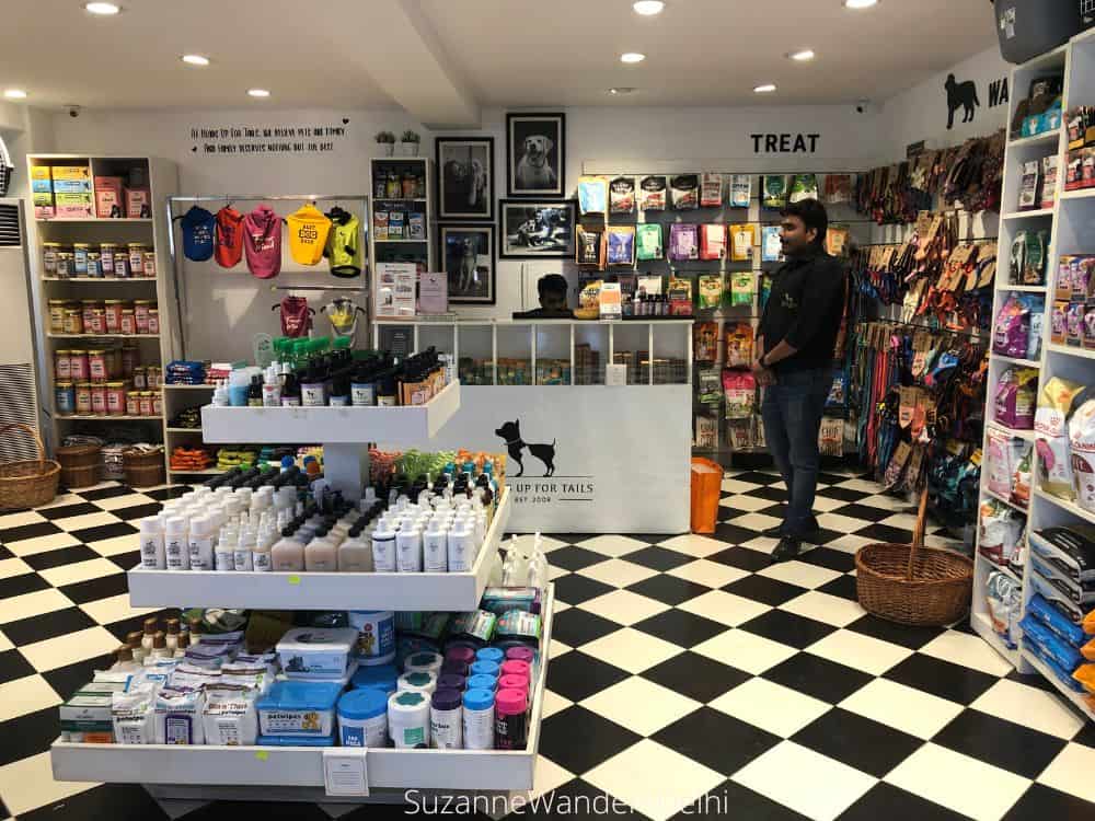 Interior of the shop showing pet items on all walls and a big display in front with black and white tile floor 