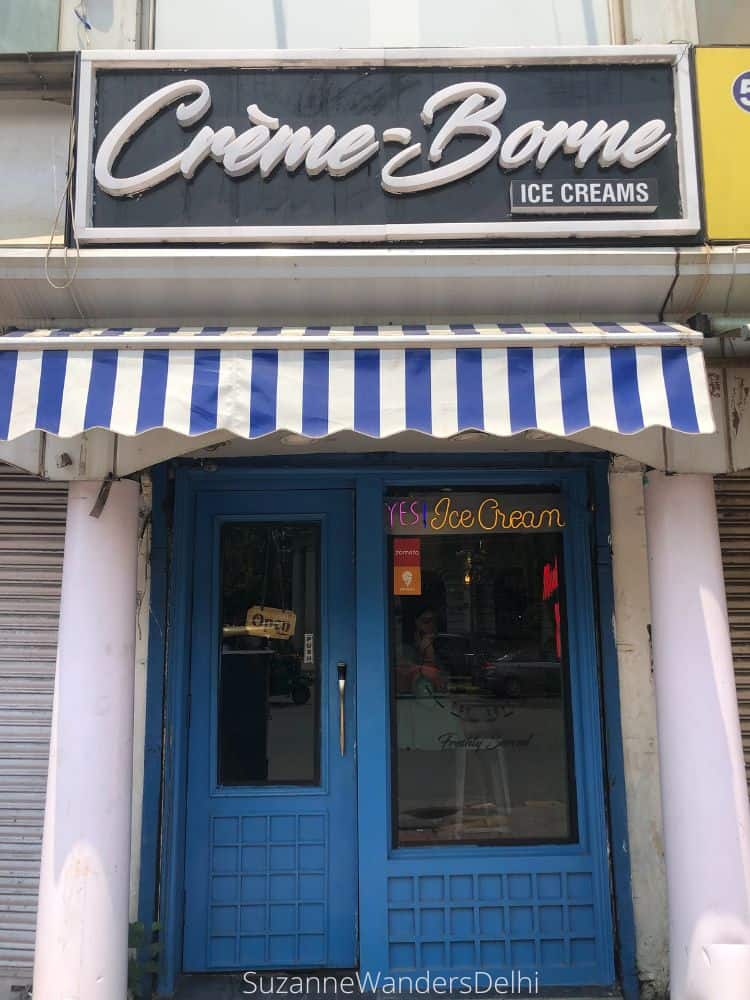 The blue front doors and blue and white awning entrance to Creme-Borne in Connaught Place 