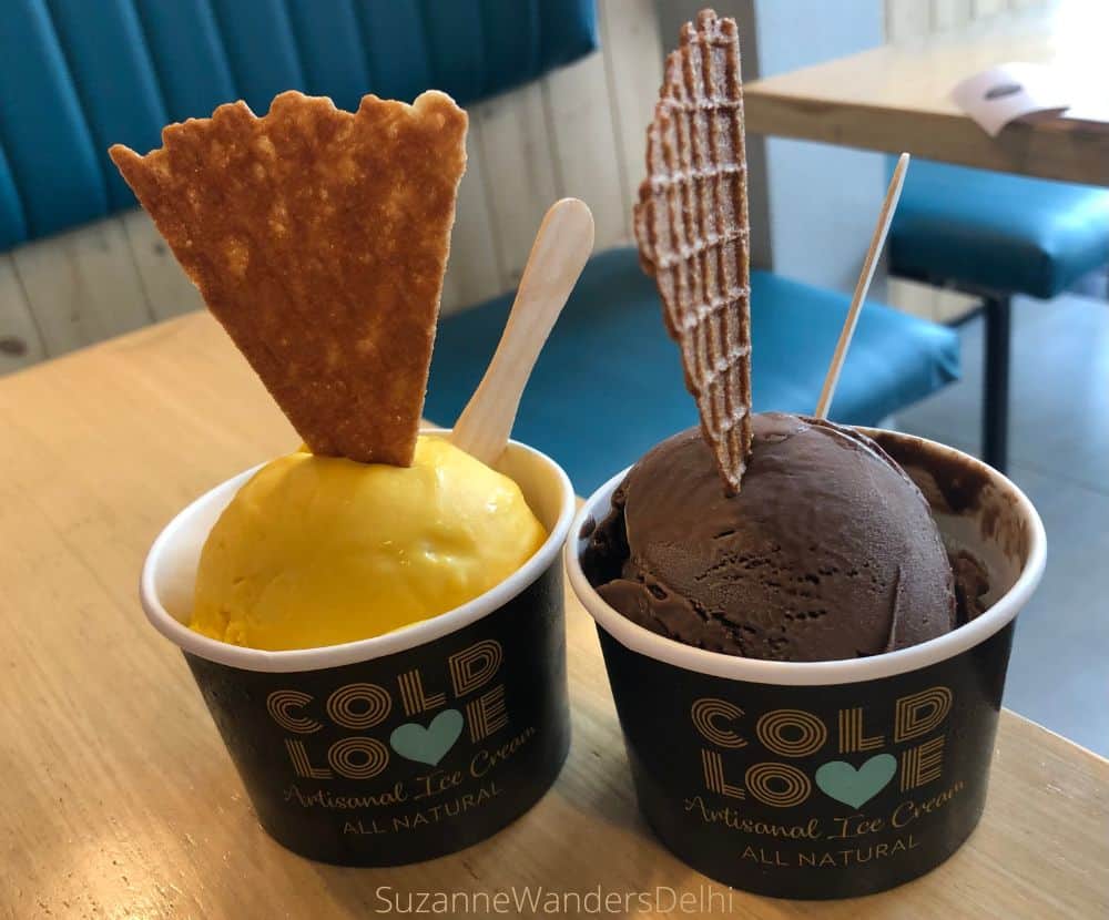 Two Cold Love cups of ice cream with triangular wafer cookies inserted - one Mango and one Chocolate Orange flavour