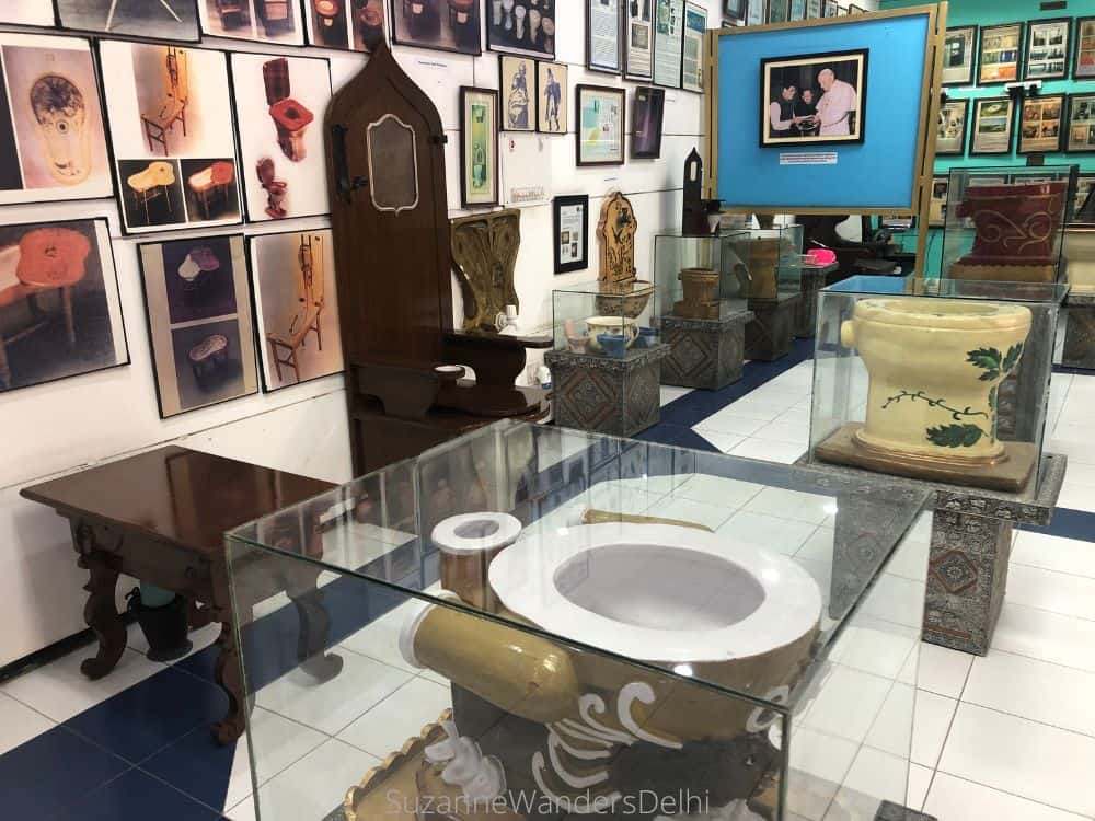 Display of historic toilets and many exhibits on walls at Sulabh International Museum of Toilets, one of the best museums and galleries in Delhi