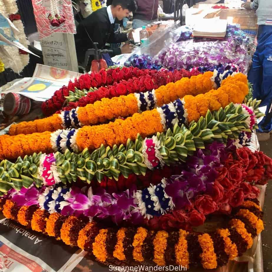 Stack of floral garlands in different colours at the Ghazipur Phool Mandi, one of Delhi's best off the beaten path sites.