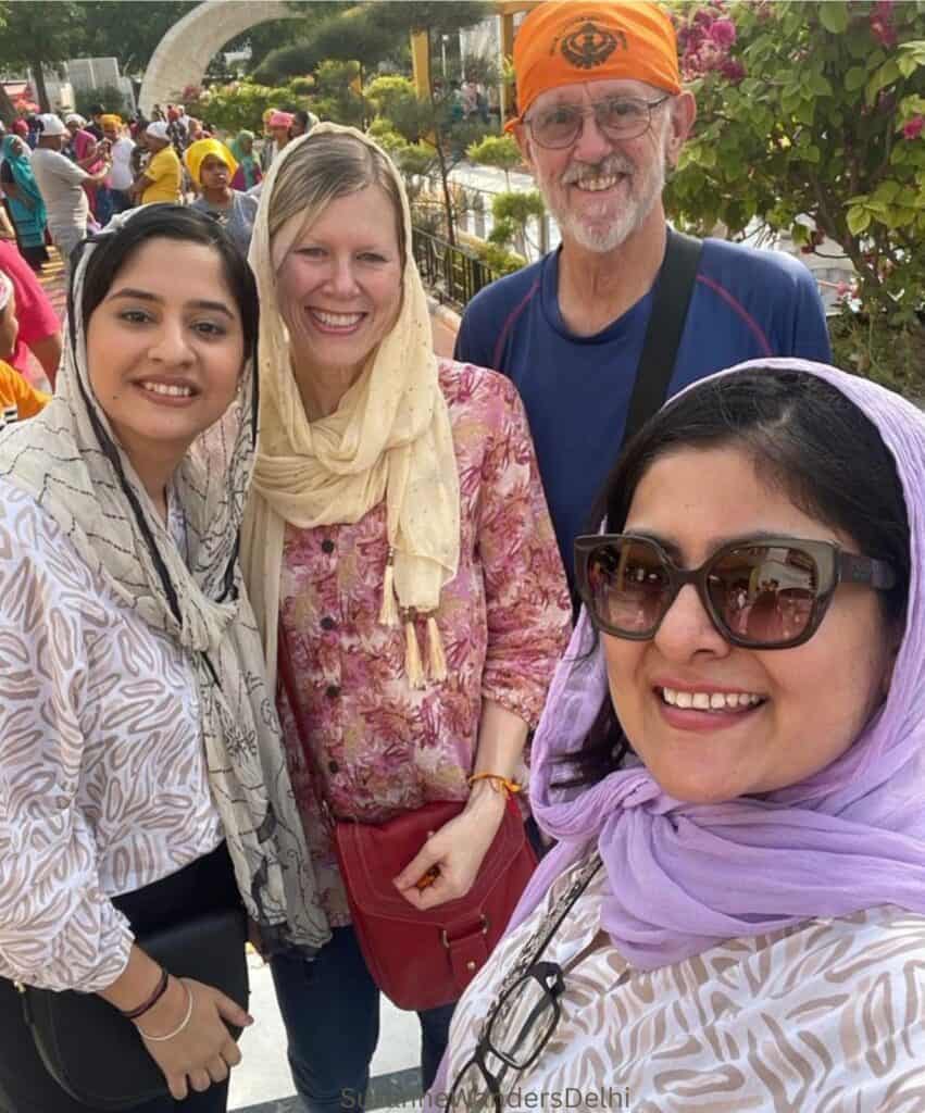 The author and 3 friends wearing dupattas and bandanas outside Gurudwwra Bangla Sahib, one of the best places for a first time visitor to Delhi