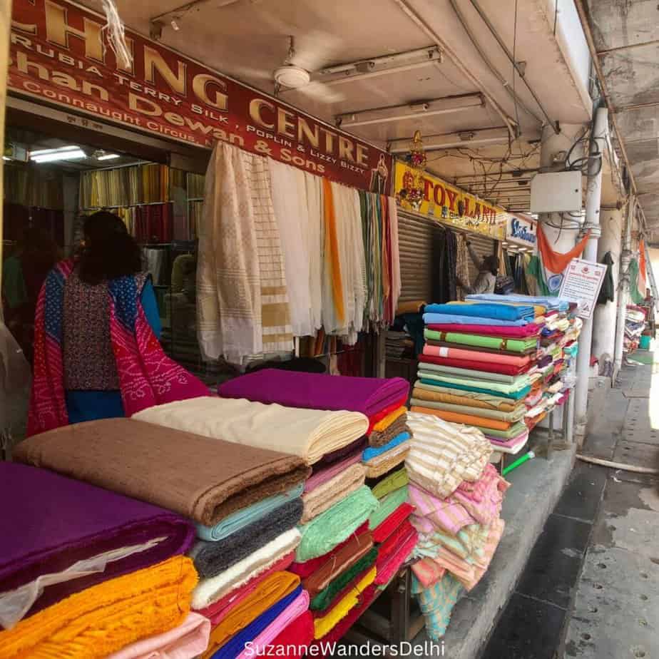 Bolts of fabric laid out on tables for display at Shankar Market