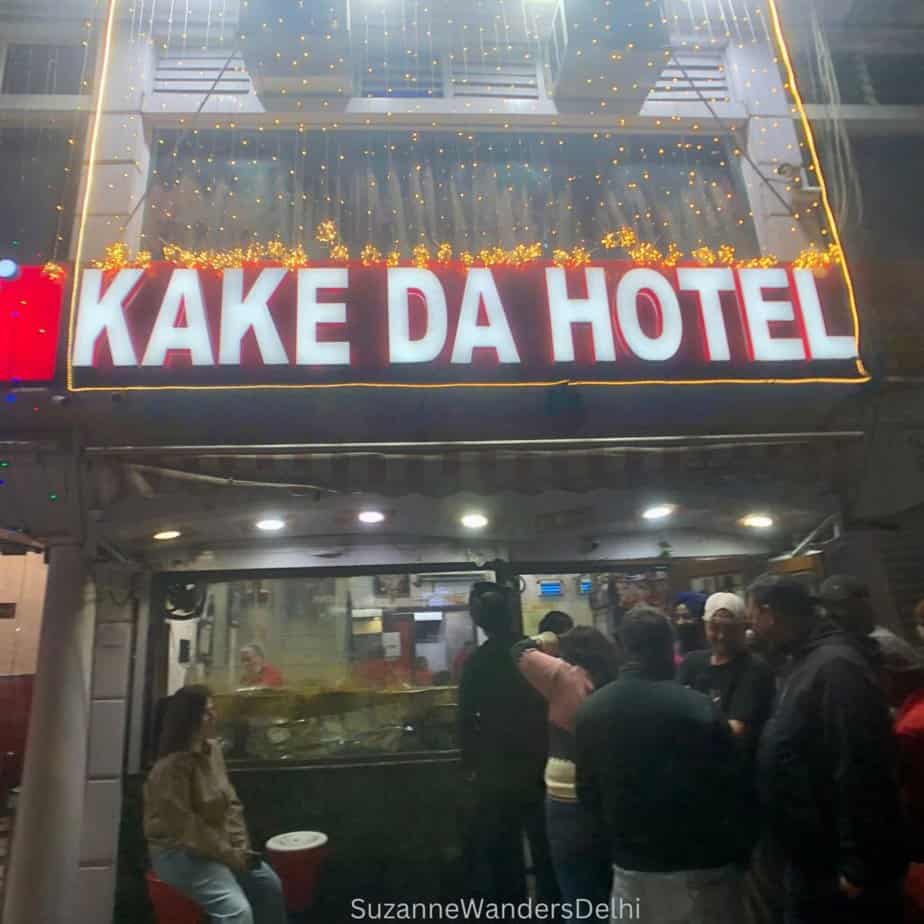 Exterior view of Kaka Da Hotel with crowd of people waiting to get in at night