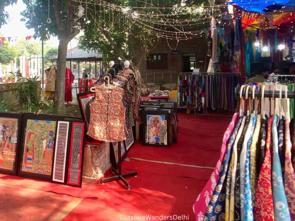 Outdoor clothing and Indian prints stall with red carpeting at Dilli Haat, one of the best markets for a first time visitor to Delhi