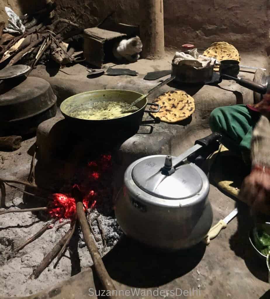 Two pots and chapatis cooking on the traditional fire pit stove