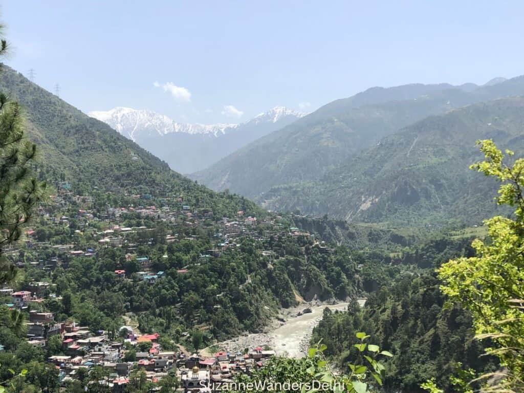 View of Chamba from a distance with the Ravi River and snow covered mountain peaks in the distance