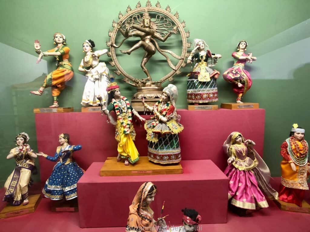 display of dolls in Indian tribal constumes on a raised red display stand at Shankar's International Dolls Museum