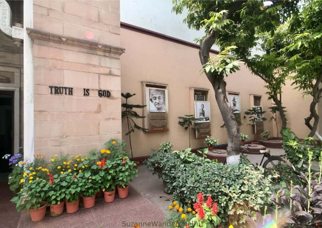 The entrane way with Gandhi's quote "truth is God" on the wall and plants and trees.