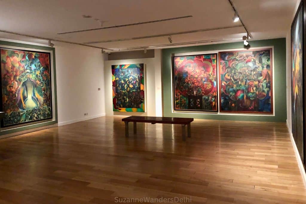 gallery with large colourful paintings and wooden floors at Kiran Nader Museum in Delhi