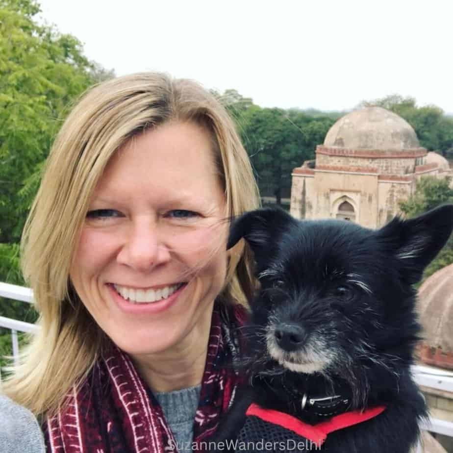 the author and her little black dog on a terrace wtih Firoz Shah Tughlaq's tomb in the background, Delhi