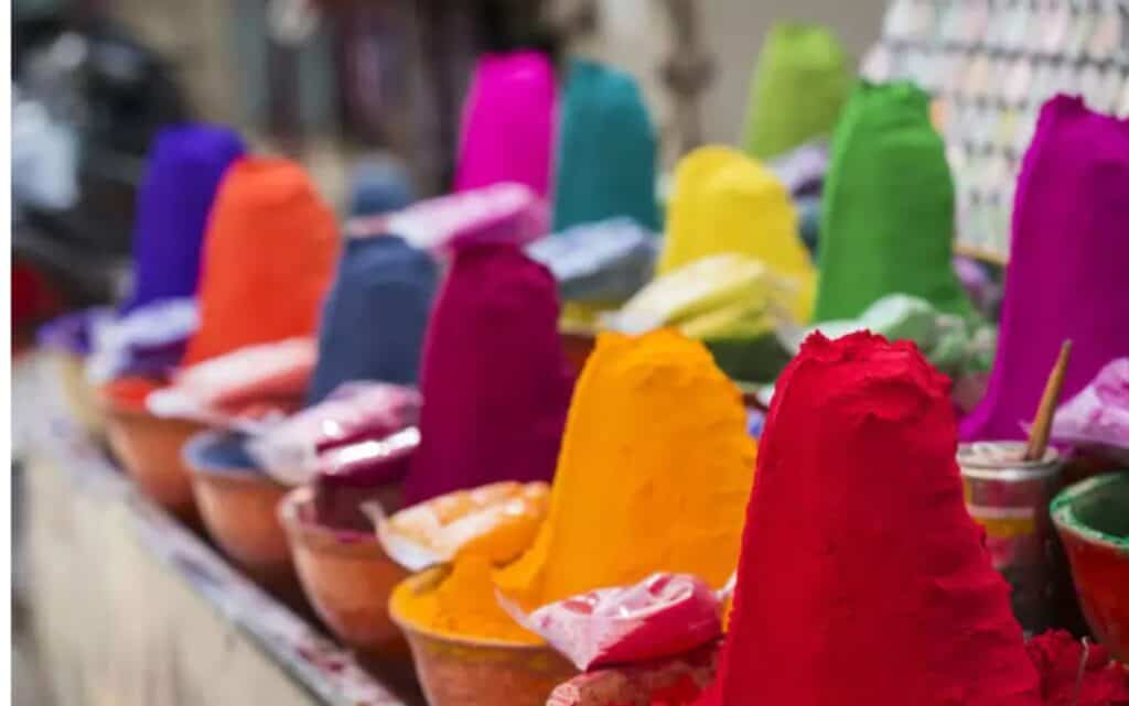 Piles of coloured powders on display in a Delhi market/ How to Celebrate and Play Holi in Delhi Safely