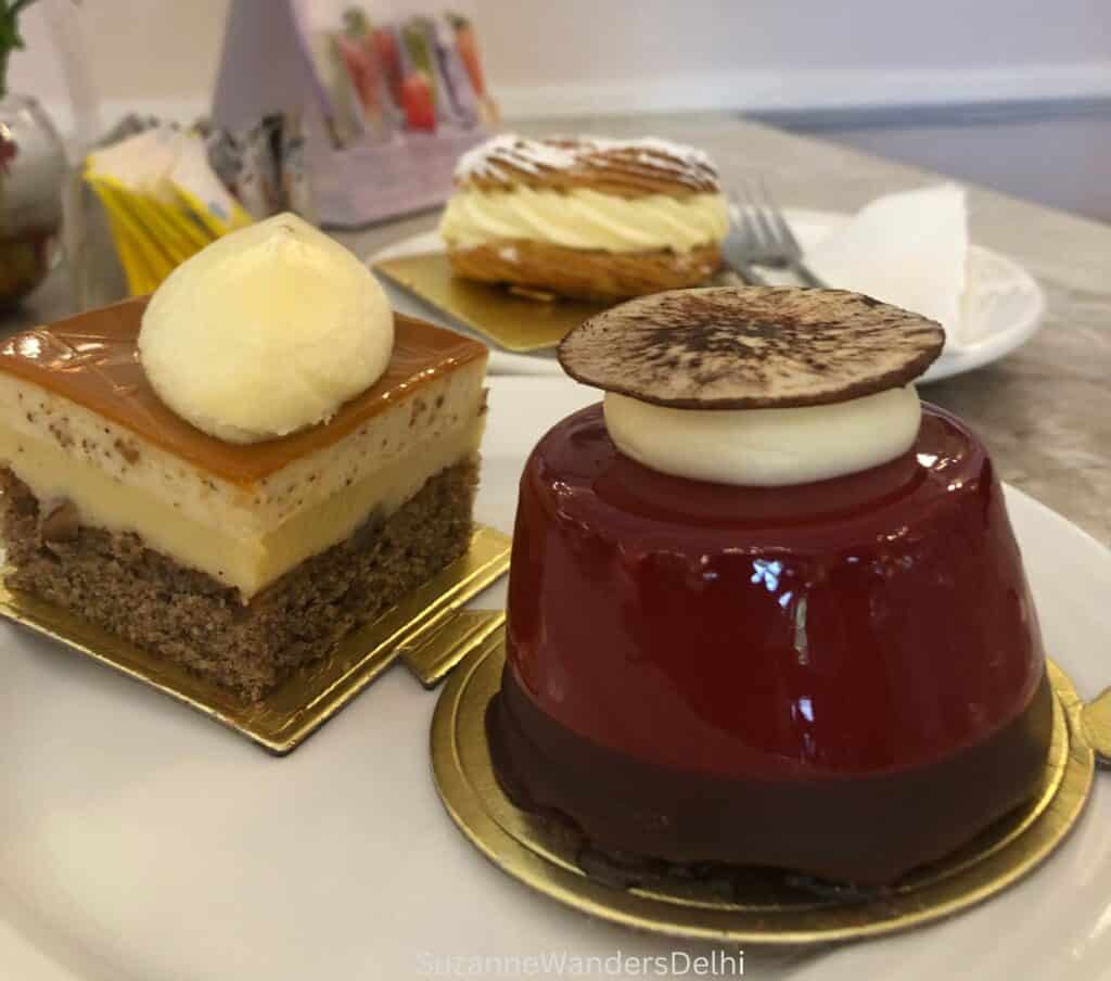 Three fine pastries on a plate in L'Opéra, one of the best bakeries in Delhi