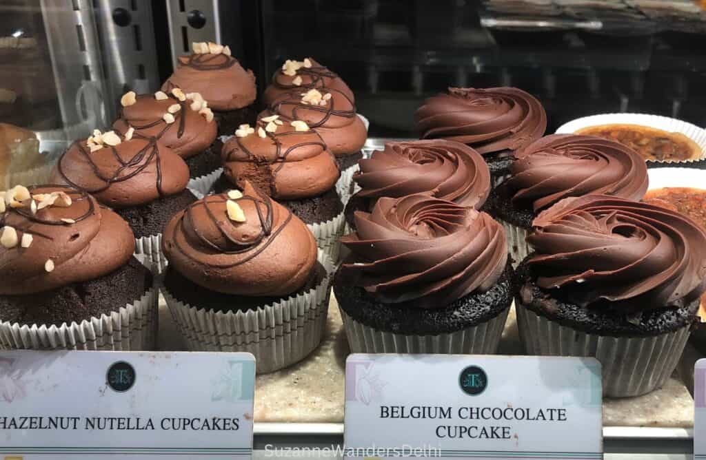 A display of chocolate cupcakes in the Theos display case