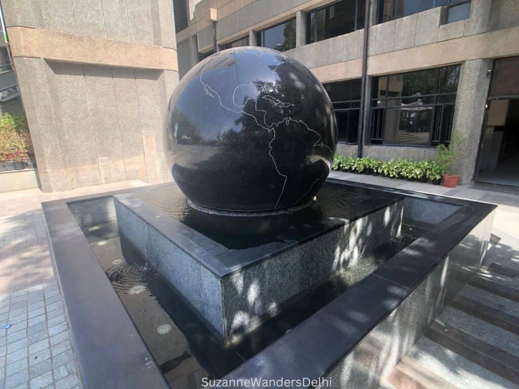 Giant black granite ball floating on water outside of the National Science Centre, one of the best museums and galleries in Delhi
