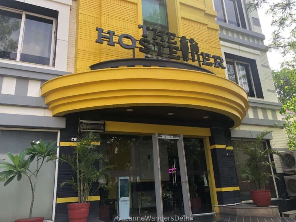 The exterior entrance of The Hosteller with its bright yellow awning and signage
