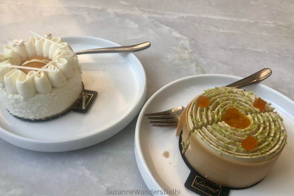 two petite cakes on white plates with forks at Lavonne Cafe in Delhi