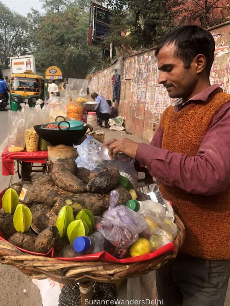 A shakarkandi ki chaat seller behind his stand preparing the chaat; this is a common winter Delhi street food