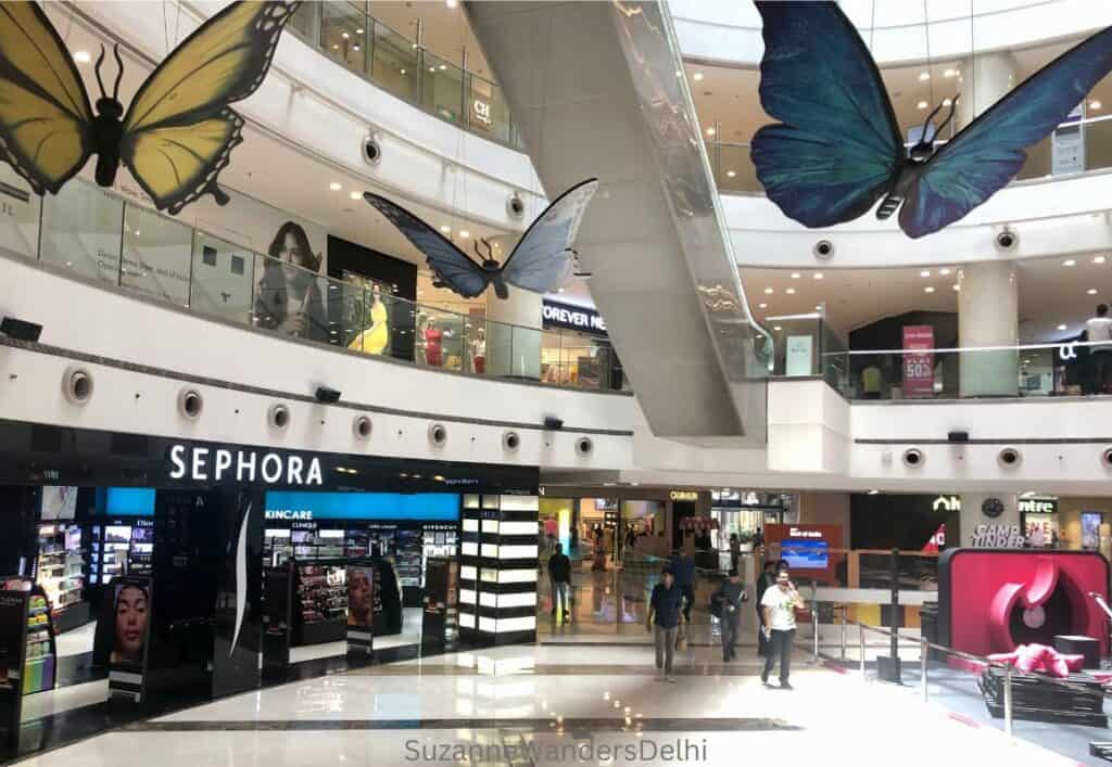 inerior of DLF Mall of India with large butterflies hanging from ceiling and showing the Sephora store