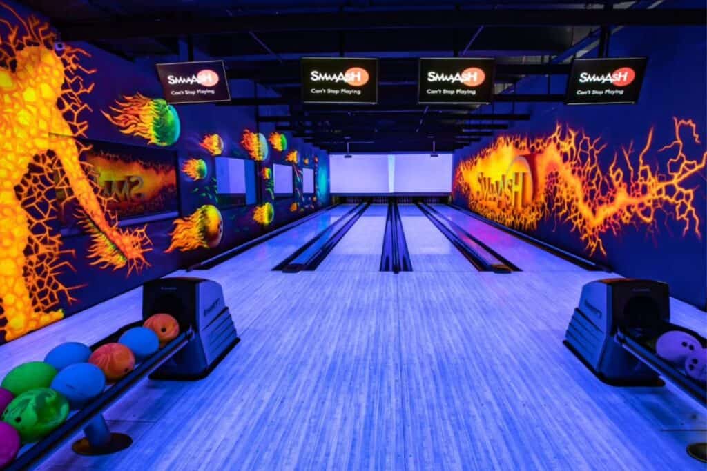 A two lane bowling alley with purple lighting and colourful bowling balls, one of the most fun places to visit with kids in Delhi