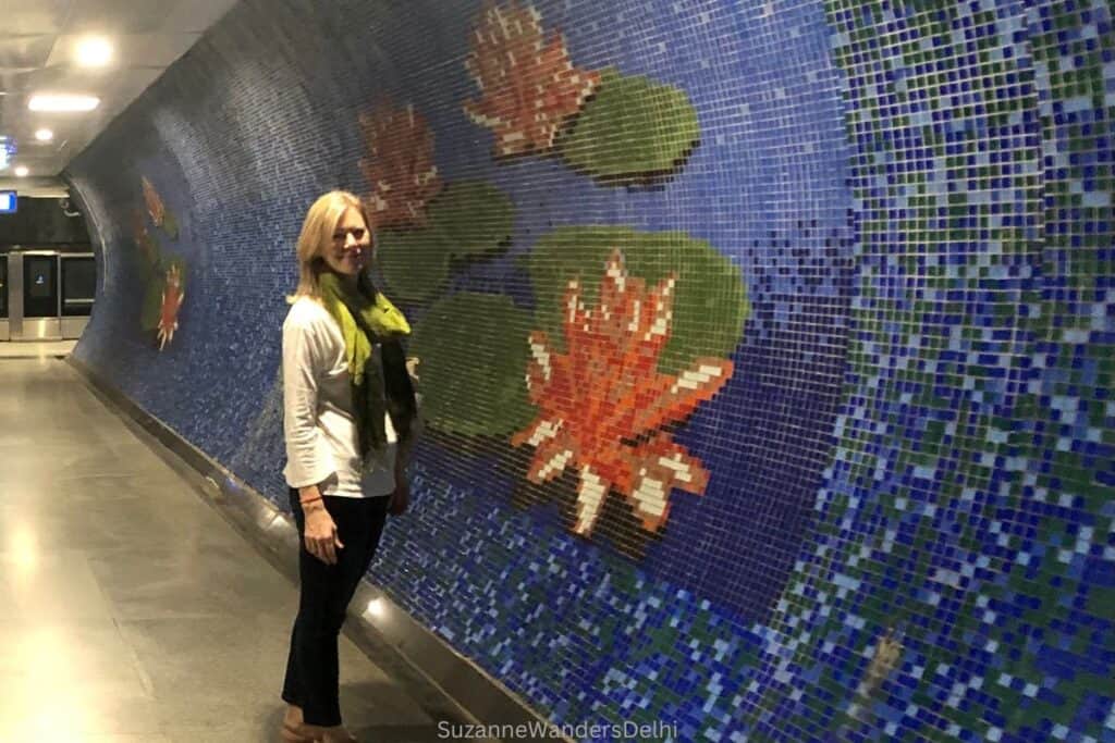 the author inside the Chawri Bazaar metro station in front of a blue tiled wall with flower design