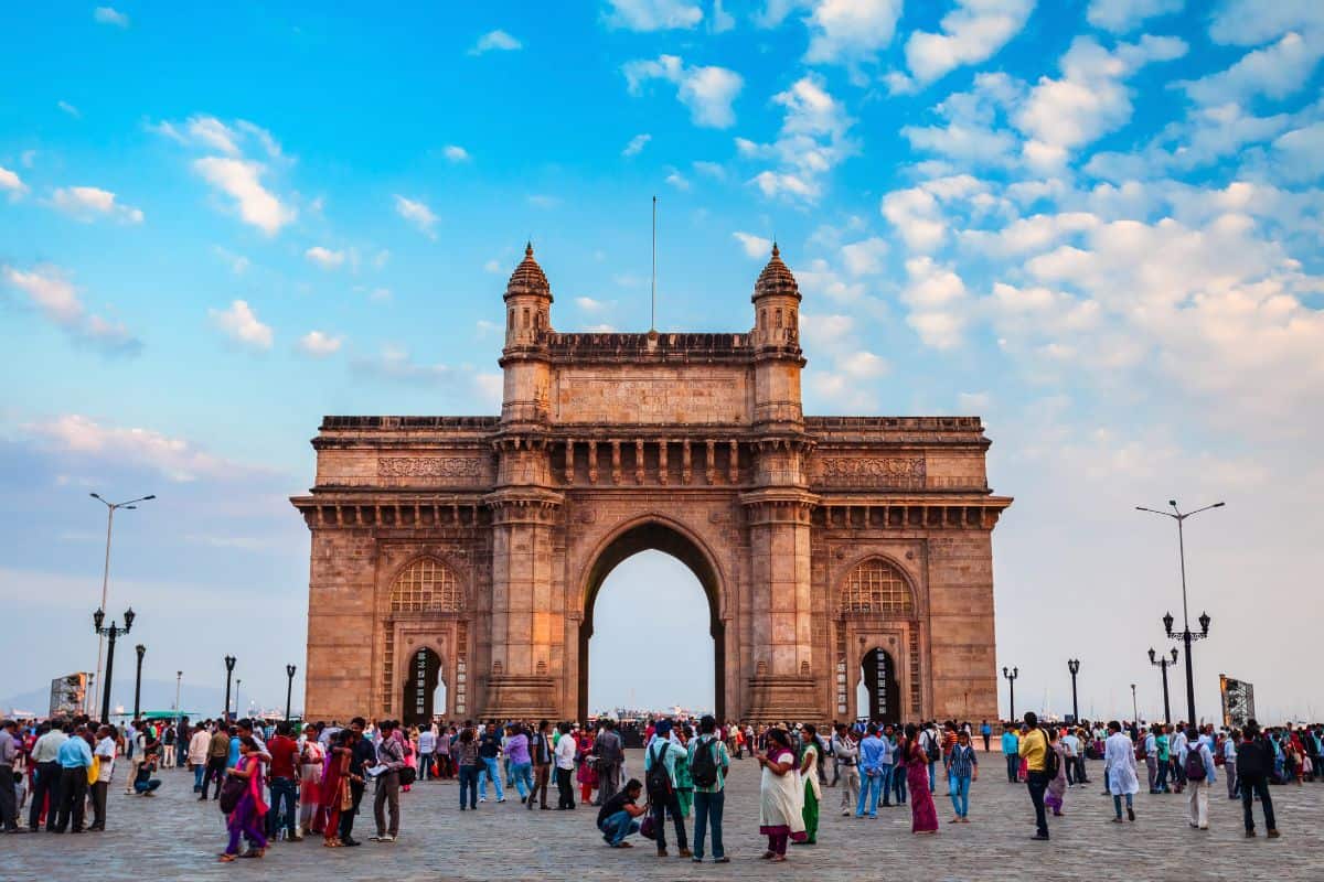 The Gateway of India with brilliant blue sky in background and crowd in front, in Mumbai