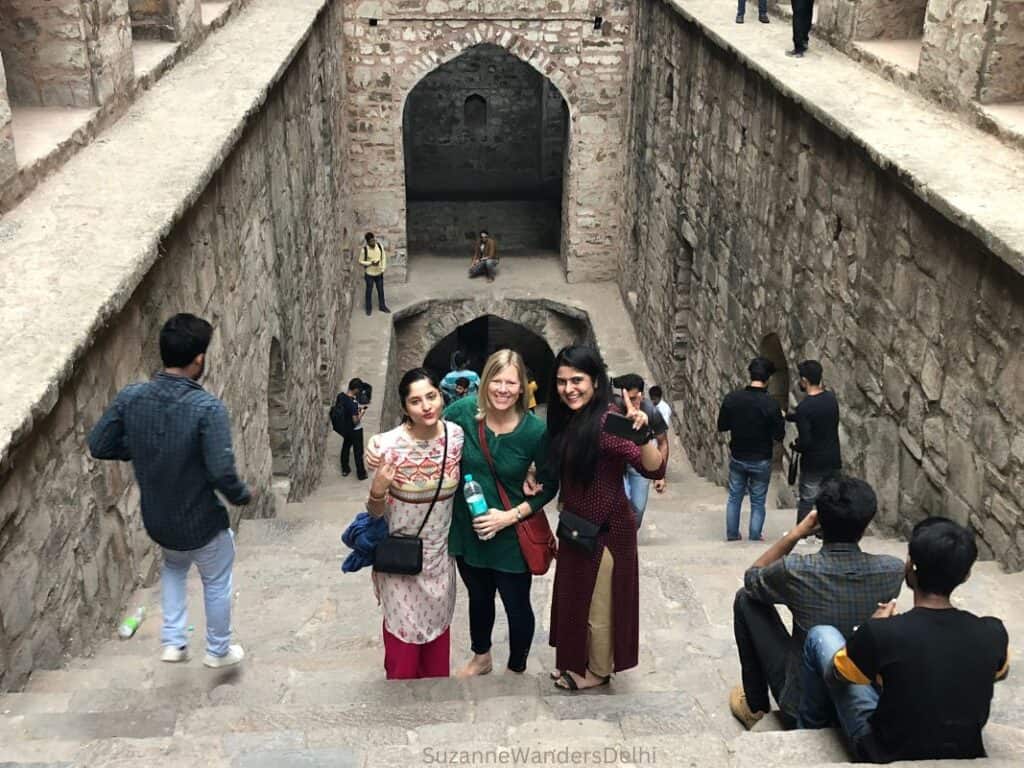 the author with two friends standing in Agrasen ki Baoli, one of Delhi's historic stepwells