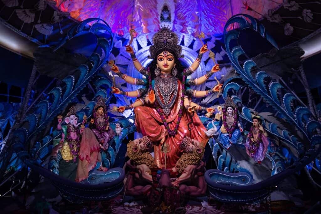 Pandal at night of Durga with her children, bathed in bue and purple lights