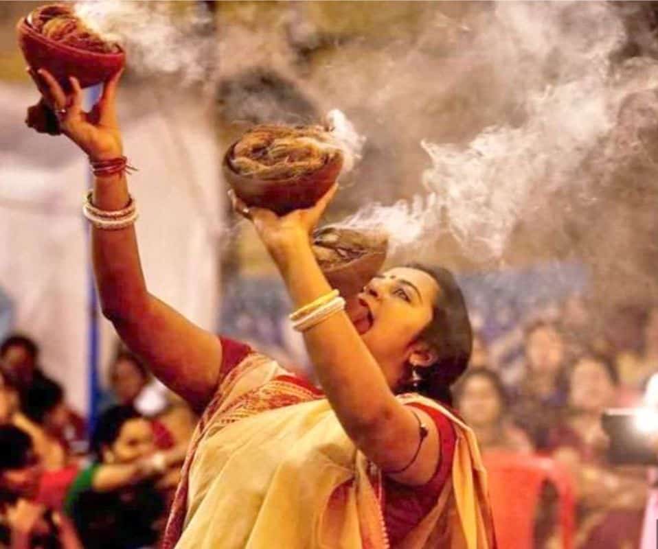Indian woman performing tradtional dhanuchi nach during Durga Puja in Delhi
