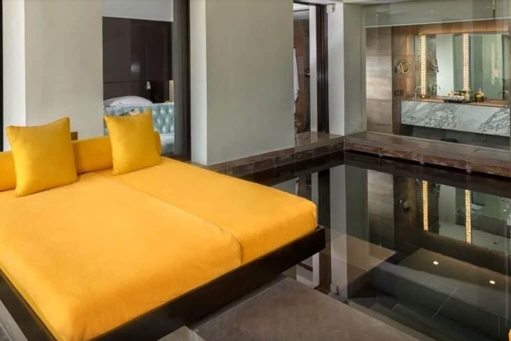 A room with orange daybed and plunge pool at the Lodhi hotel in Delhi