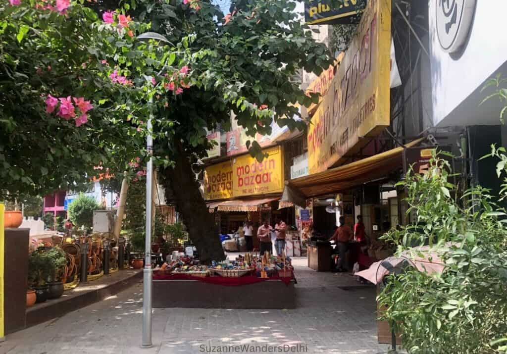 View of Priya Complex in Delhi, with blooming trees and Modern Bazaar shop