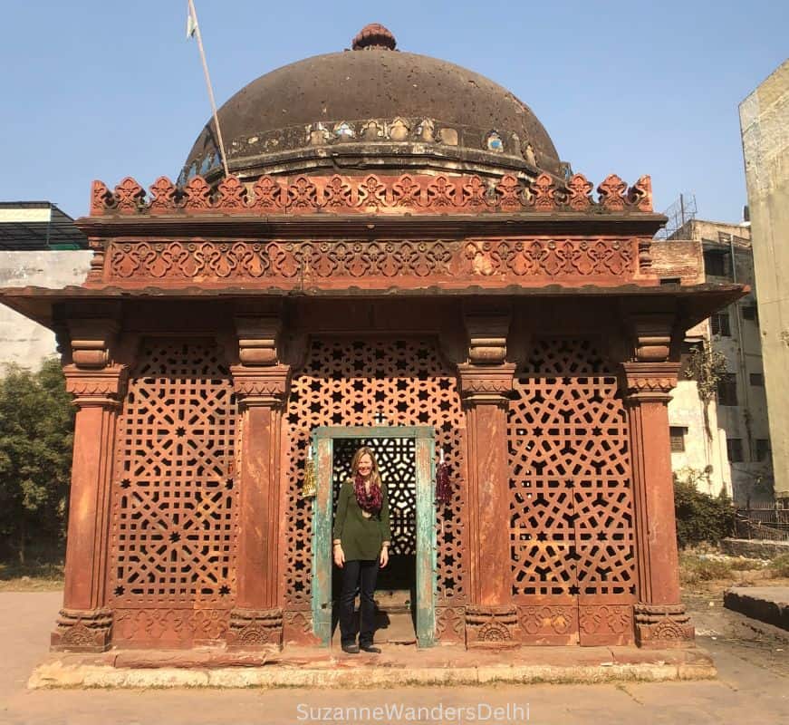 the author standing in the doorway of Sheikh Yusuf Qattal's tomb, the walls are heavily carved with jali