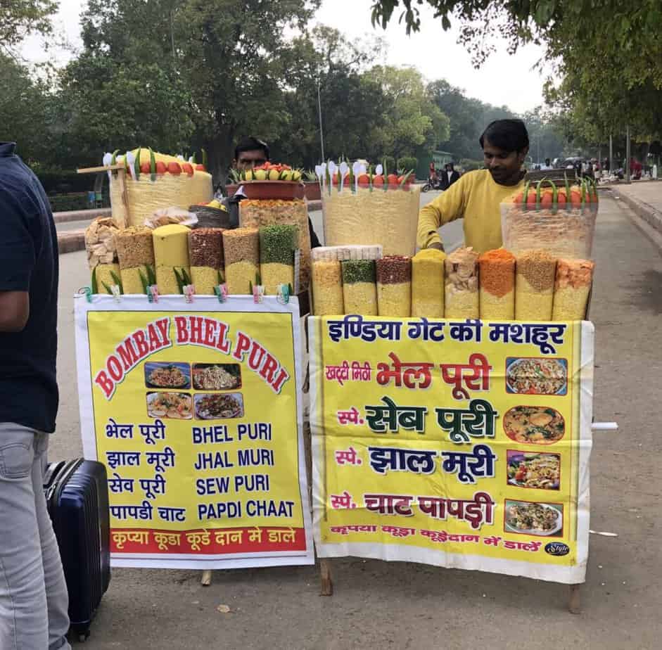 bhel puri stand on treed Delhi street.  Bhel puri is usually safe for tourists to eat in India. 