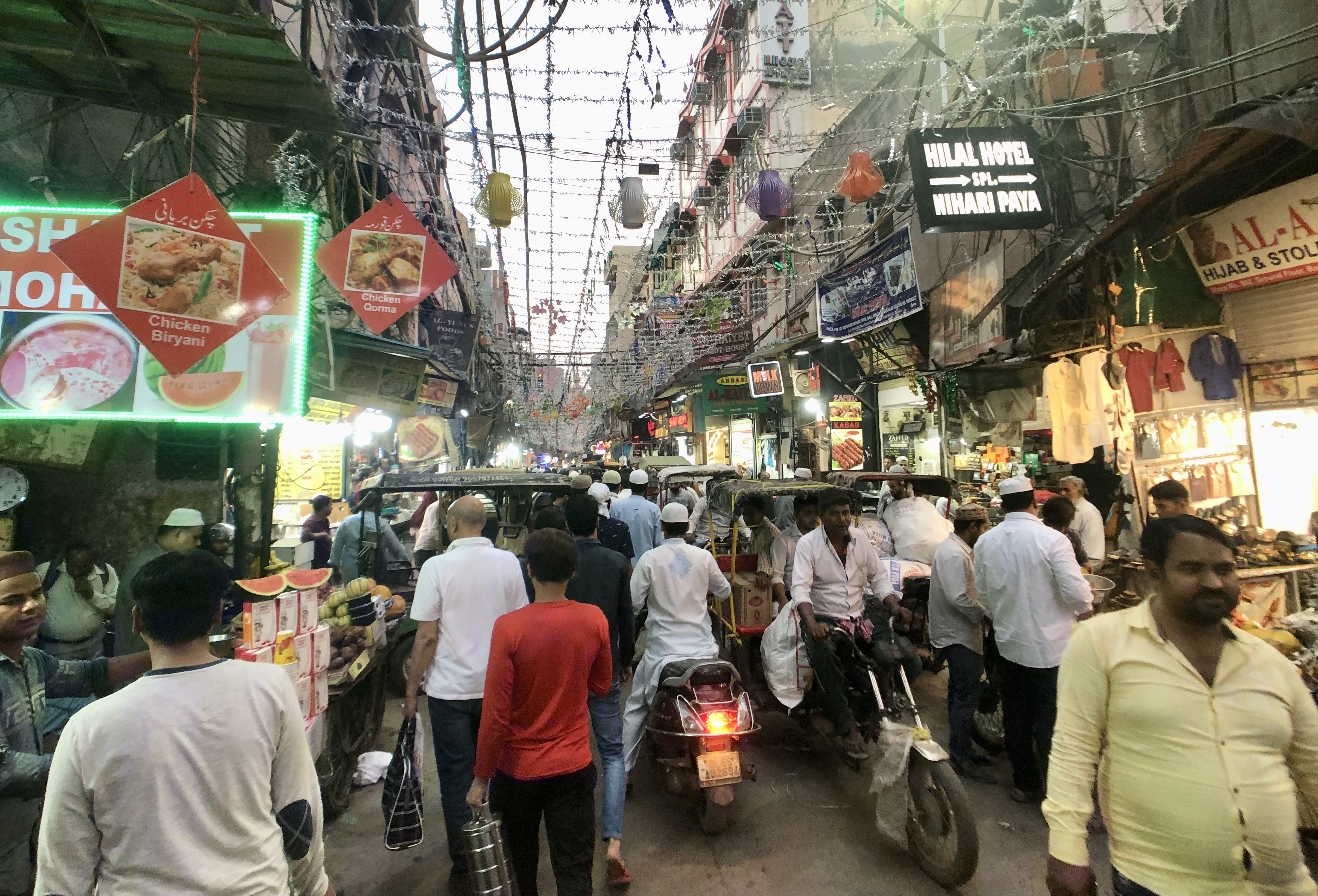 Matia Mahal road at dusk busy with people and motorcycles - this is a must on a heritage walk of Old Delhi