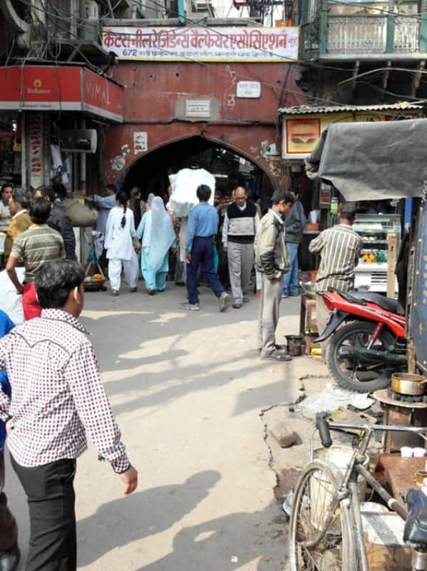 The Katra Neel gateway in Old Delhi on a busy street with pedestrians