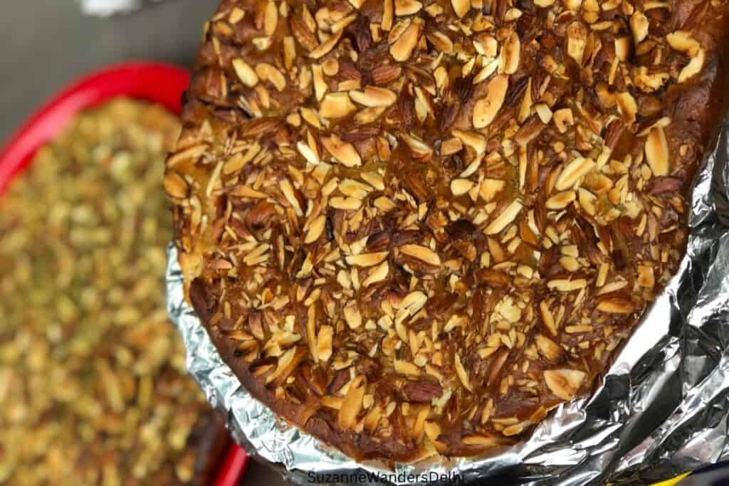 A stack of nut topped sheermal wrapped in aluminum foil at Haji Nadeem Shahi Sheermal, one the secret places to go to on an Old Delhi food tour