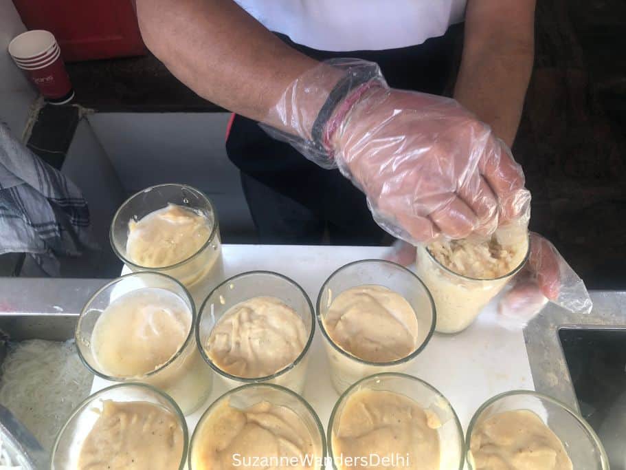 9 glasses of rabri faluda and man filling them