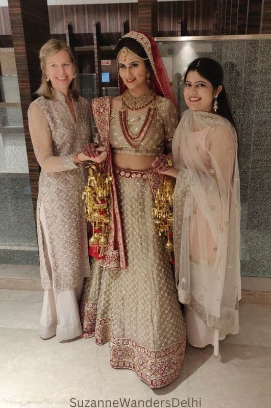 the author, an Indian bride and Indian friend all in traditional clothing at an Indian wedding, one of the best ways to get cultural in Delhi