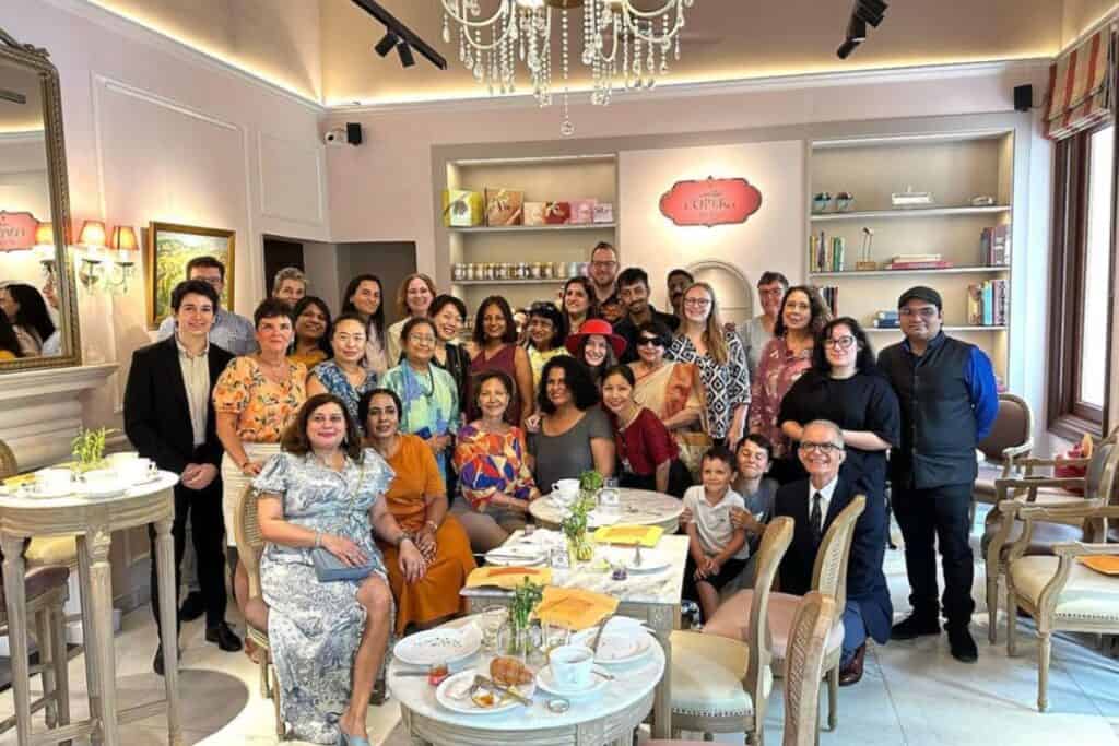 Large group of people sitting and standing inside a fancy coffee house at a Delhi Accueil event, one of the best social networks in Delhi for expats