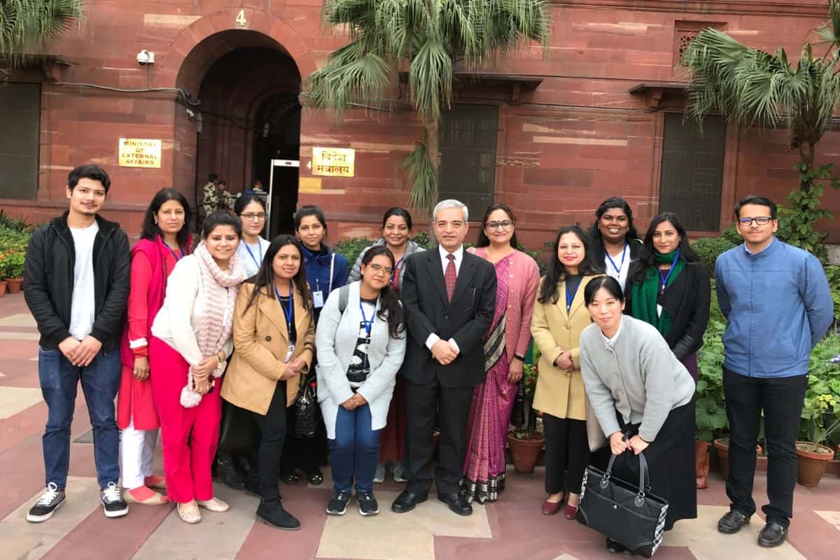 group of Japanese and Indian adults standing outside in front of red sandstone building in Delhi