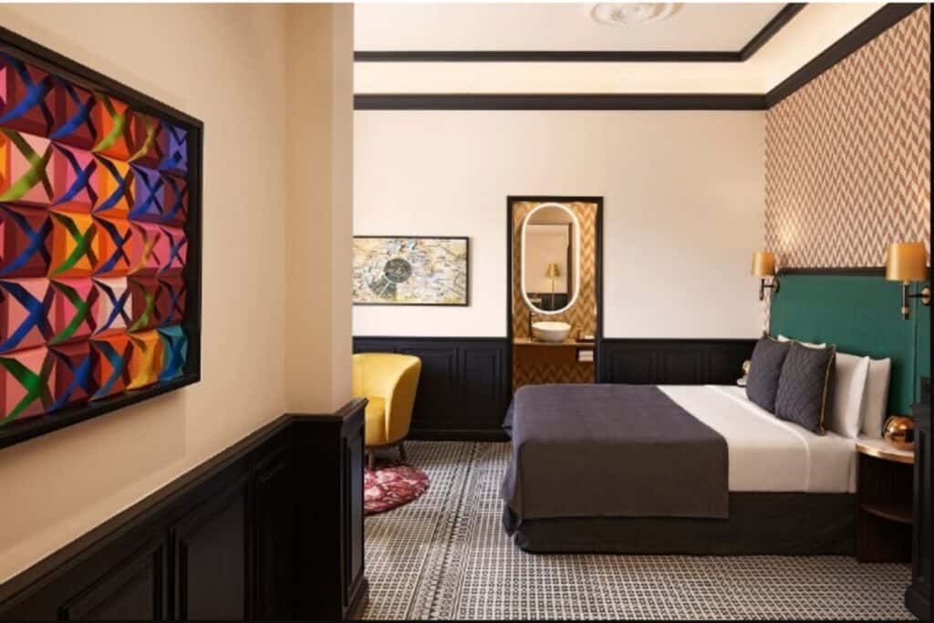 side view of queen size bed with art on the left wall in the Connaught 